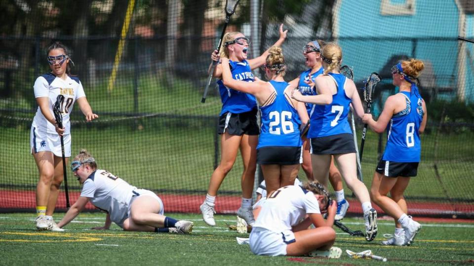 Lexington Catholic’s Lily Hester, leaping in center, celebrates after scoring the winning goal in the second sudden-death overtime against Sayre in the Commonwealth Lacrosse League girls’ championship game Saturday at Transylvania. It was the Knights’ first win in four attempts this season against the Spartans.