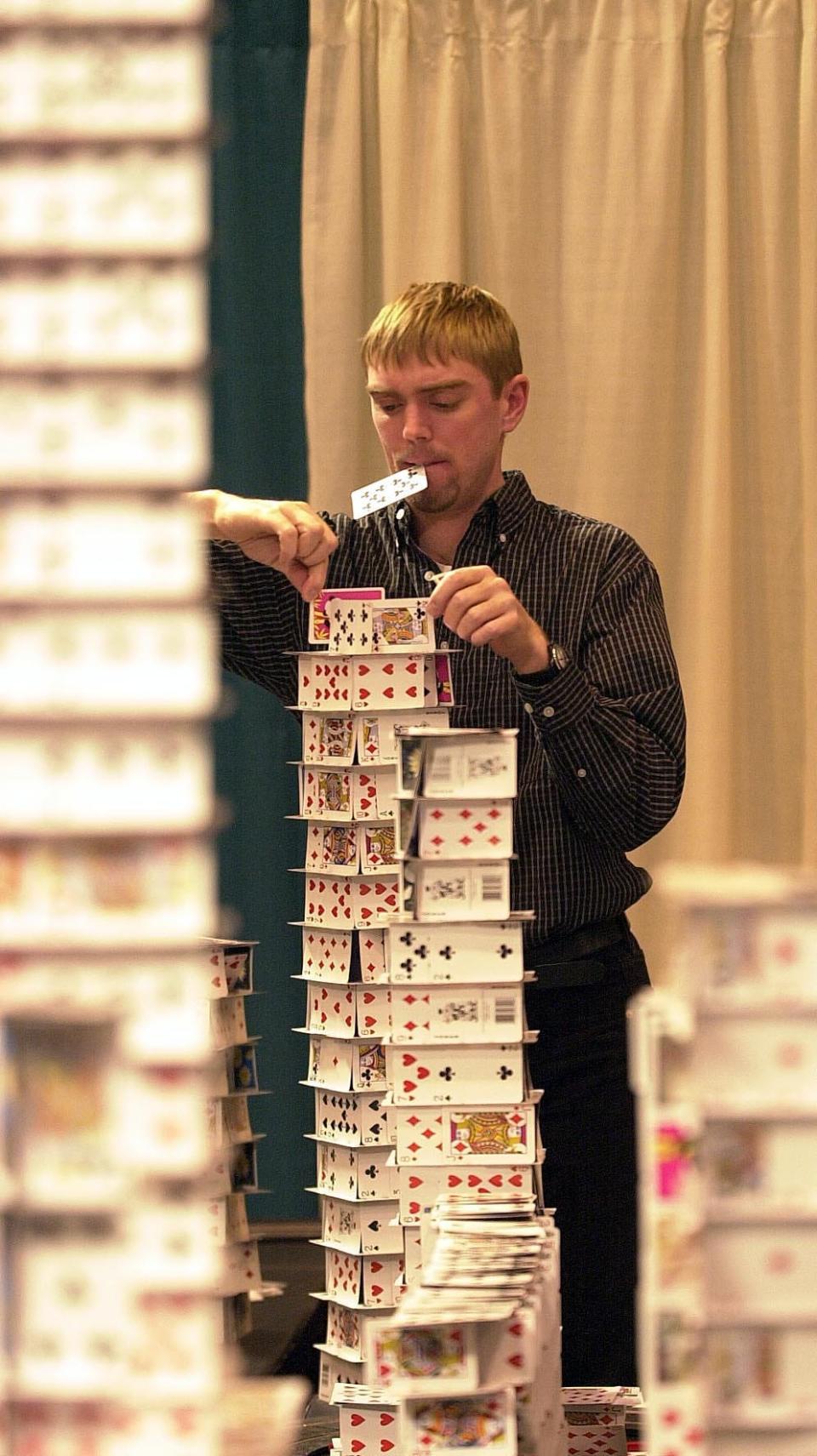 World-record cardstacker Bryan Berg works on a new creation among towers of playing cards.