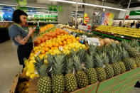 An employee checks prices of lemons at a 365 by Whole Foods Market grocery store ahead of its opening day in Los Angeles, U.S., May 24, 2016. REUTERS/Mario Anzuoni