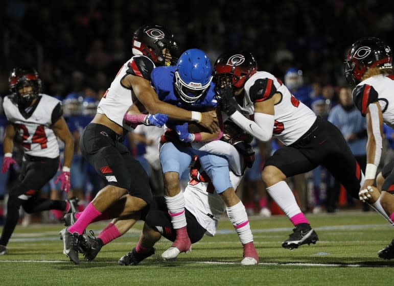 NORCO, CA - OCTOBER 15, 2021: It takes three Corona Centennial defenders to bring down Norco wide receiver Grant Gray (1) in the first half at Norco High School on October 15, 2021 in Norco, California.(Gina Ferazzi / Los Angeles Times)