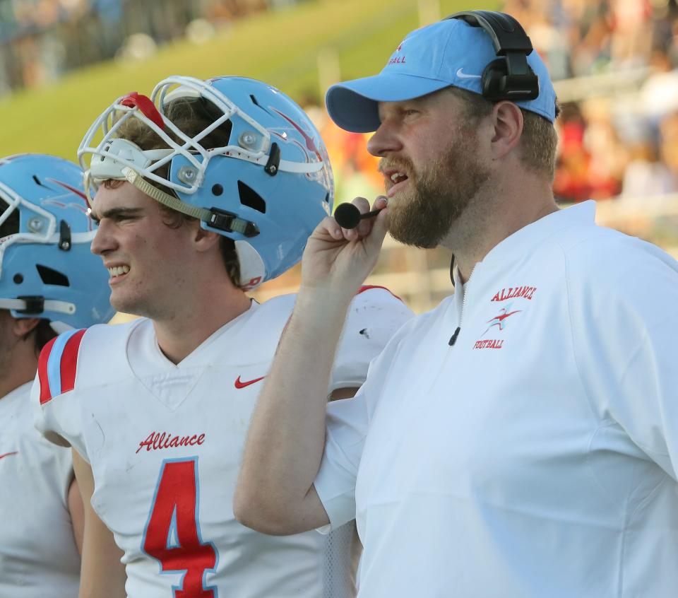 Alliance quarterback Brendan Zurbrugg, left, and head coach Tim Goodman, right, on the sideline at Lake, Friday, Aug. 18, 2023.