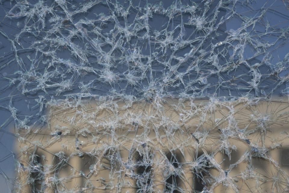 A detail of the installation "Vice President Kamala Harris Glass Ceiling Breaker" is seen at the Lincoln Memorial, reflected, in Washington, Wednesday, Feb. 4, 2021. Vice President Kamala Harris' barrier-breaking career has been memorialized in a portrait depicting her face emerging from the cracks in a massive sheet of glass. Using a photo of Harris that taken by photographer Celeste Sloman, artist Simon Berger lightly hammered on the slab of laminated glass to create the portrait of Harris. (AP Photo/Carolyn Kaster)