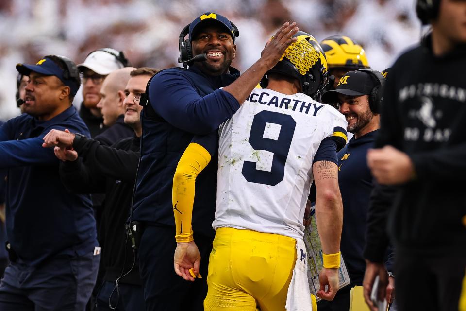 Acting head coach Sherrone Moore of the Michigan Wolverines celebrates with J.J. McCarthy after an offensive touchdown during the second half against the Penn State Nittany Lions at Beaver Stadium on November 11, 2023 in State College, Pennsylvania.