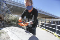 Buffalo Bayou Partnership director of Public Relation and events Trudi Smith tries to save Mexican Free-tailed bats after falling from the bridge at Waugh Drive in Buffalo Bayou Park, where it was impacted by the winter storm Monday, Feb. 22, 2021, in Houston. Diana Foss, Texas Parks and Wildlife Urban Wildlife Biologist said that the winter bat colony is about 100,000. She said they were able to find about 20 bats that have fallen from the bridge that were still alive and they are attempting to save. (Steve Gonzales/Houston Chronicle via AP)