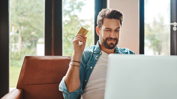 Cropped shot of a handsome young man shopping online while chilling on the sofa at home.