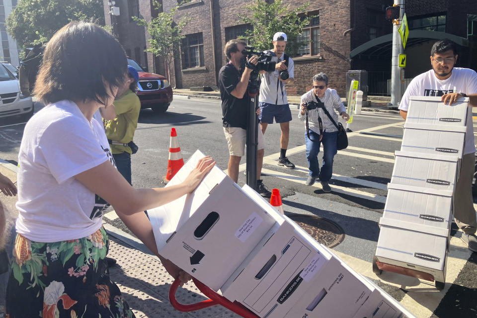 Activists haul dozens of boxes full of signed petitions to Atlanta City Hall, Monday, Sept. 11, 2023, to force a referendum on the future of a planned police and firefighter training center. Shortly after, though, Atlanta officials refused to accept the paperwork for processing, saying the city is awaiting a court decision over whether the petitions had been turned in on time. (AP Photo/R.J. Rico)