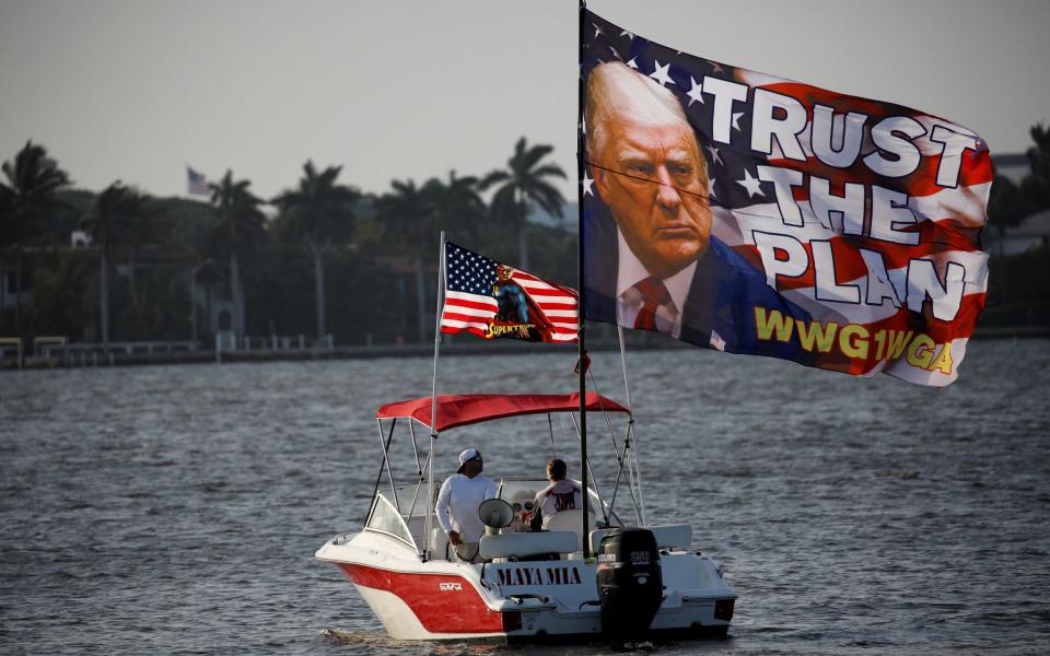 Supporters of Donald Trump express themselves on Lake Worth Lagoon behind his Mar-a-Lago resort after he messaged about his impending arrest - Marco Bello/Reuters