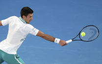 Serbia's Novak Djokovic hits a backhand to Russia's Daniil Medvedev during the men's singles final at the Australian Open tennis championship in Melbourne, Australia, Sunday, Feb. 21, 2021. (AP Photo/Hamish Blair)