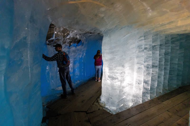 Visitors walk in a fleece covered ice cave inside the Rhone glacier in Obergoms