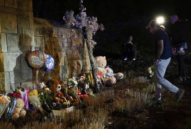 PHOTO: A man drops flowers to a makeshift memorial where balloons and Teddy bears are left on the outside the Covenant School building at the Covenant Presbyterian Church, in Nashville, Tenn., March 27, 2023. (Brendan Smialowski/AFP via Getty Images)