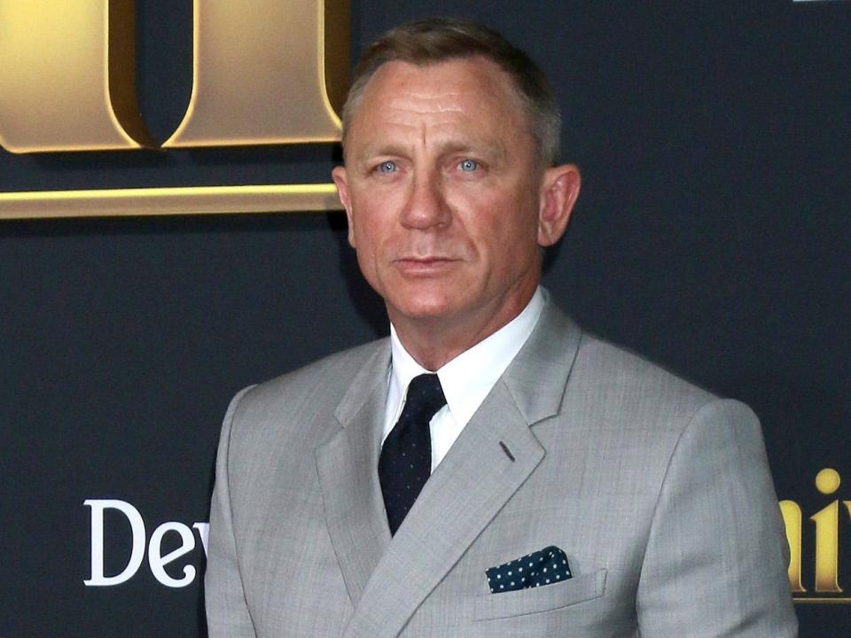 Daniel Craig in front of "Knives Out" poster on red carpet event