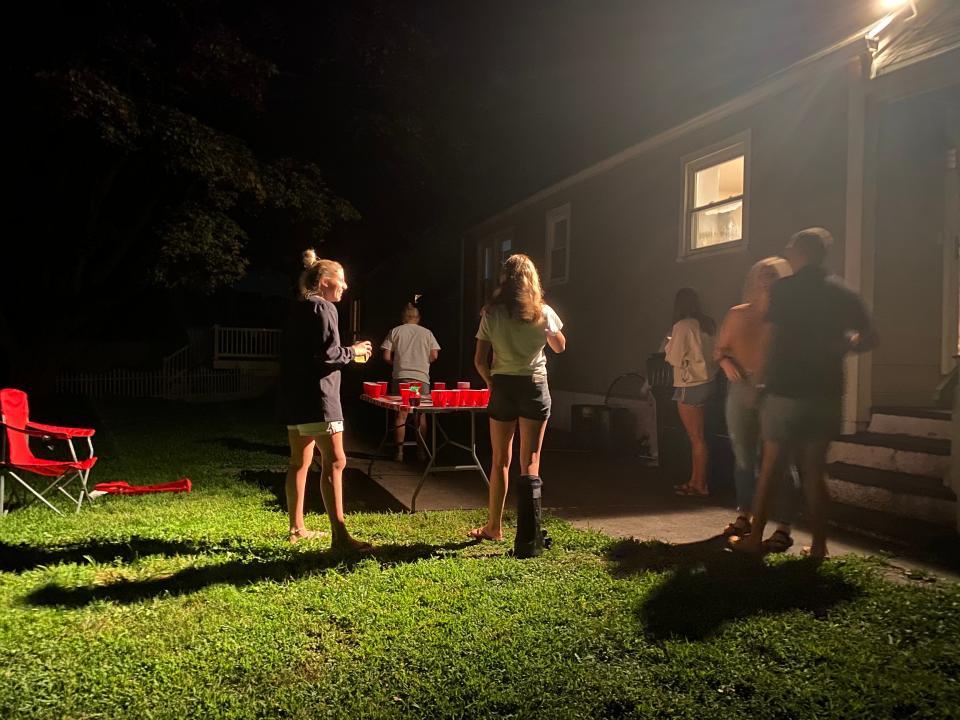 People congregate Friday at a party near the Fairfield University campus in Connecticut. A prior version of this story misstated the credit for this photo.