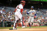 Los Angeles Dodgers' Mookie Betts (50) comes home to score on a groundout by Trea Turner during the first inning of a baseball game as Washington Nationals catcher Keibert Ruiz, left, looks on Monday, May 23, 2022, in Washington. (AP Photo/Nick Wass)