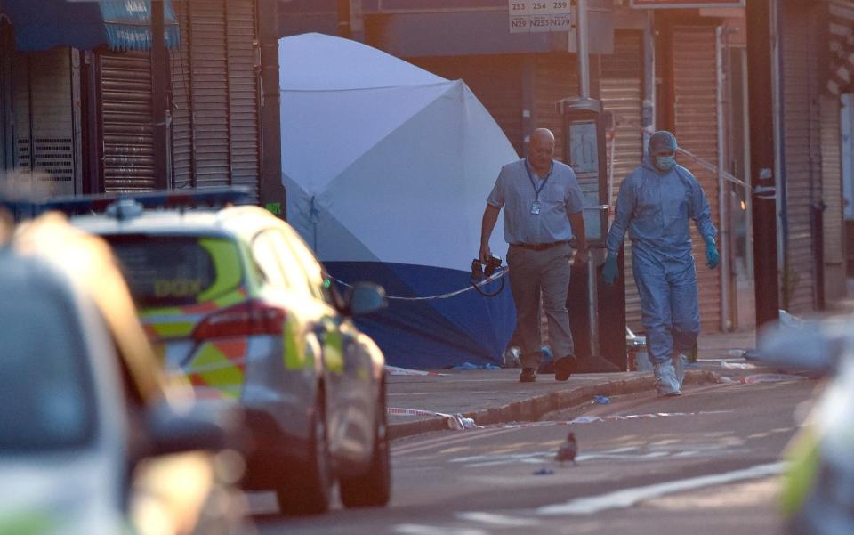  A police forensics officer walks from the scene - Credit: Carl Court/Getty