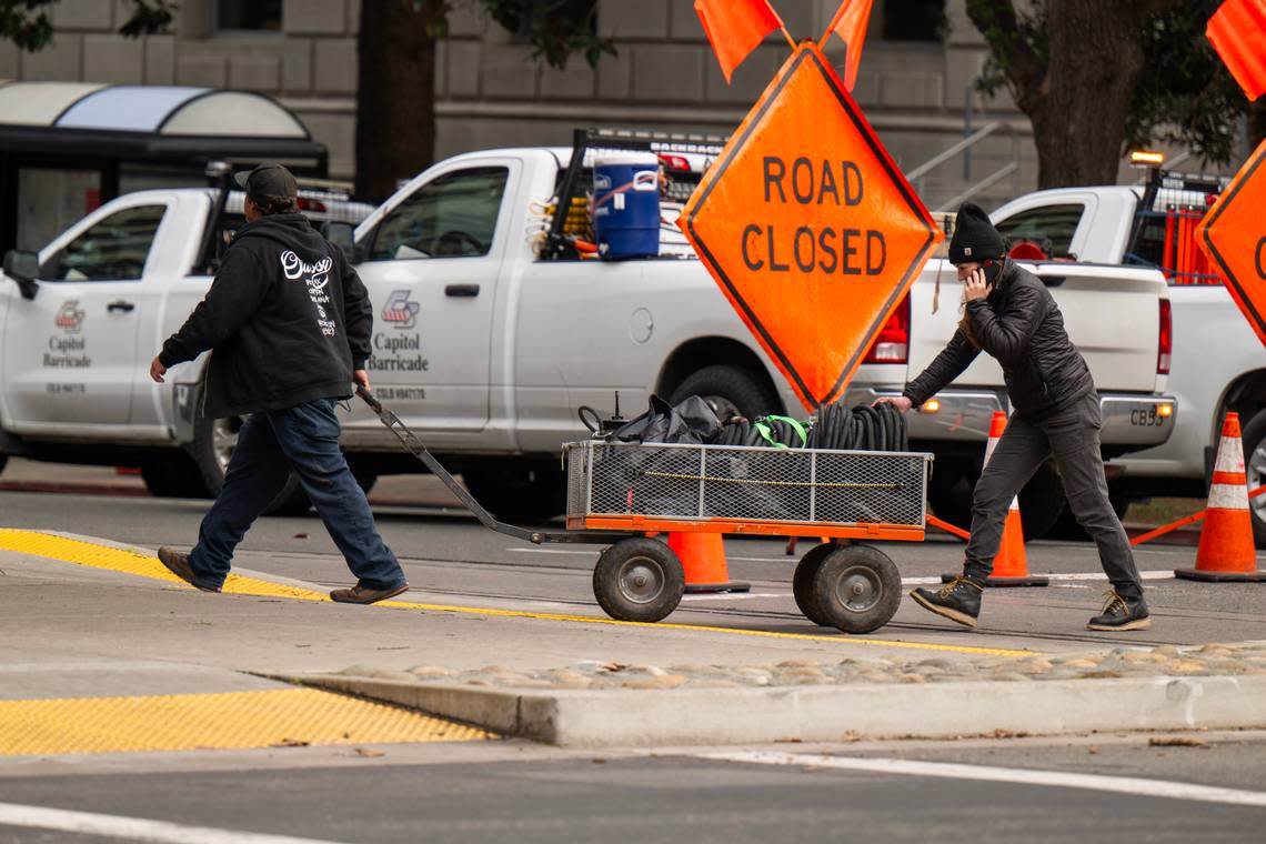 Crew members transport equipment for a scene in director Paul Thomas Anderson’s upcoming movie on H Street, closed for filming, in downtown on Saturday.