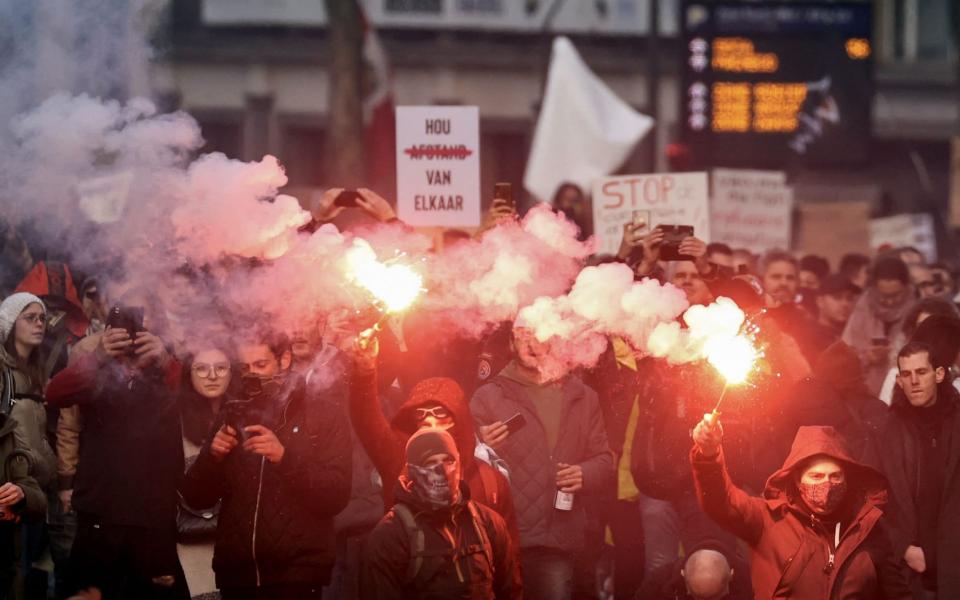 Demonstrators burn flares during a demonstration in Brussels - KENZO TRIBOUILLARD/AFP