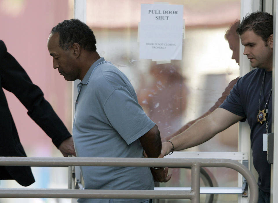 FILE - In this Sept. 16, 2007 file photo, O.J. Simpson is taken from the Las Vegas Police Investigative Services Division in Las Vegas. O.J. Simpson's attorney Malcolm LaVergne is now handling the deceased former football star, actor and famous murder defendant's financial estate. (AP Photo/John Locher, File)