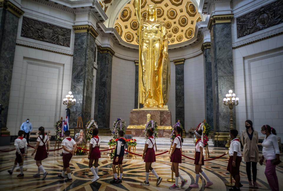 Los estudiantes caminan en fila para presentar sus últimos respetos al historiador de La Habana Eusebio Leal durante su ceremonia fúnebre dentro del "Salón de Los Pasos Perdidos", donde sus cenizas están en exhibición en el Capitolio en La Habana, Cuba, el jueves 17 de diciembre de 2020. (AP Foto/Ramón Espinosa)