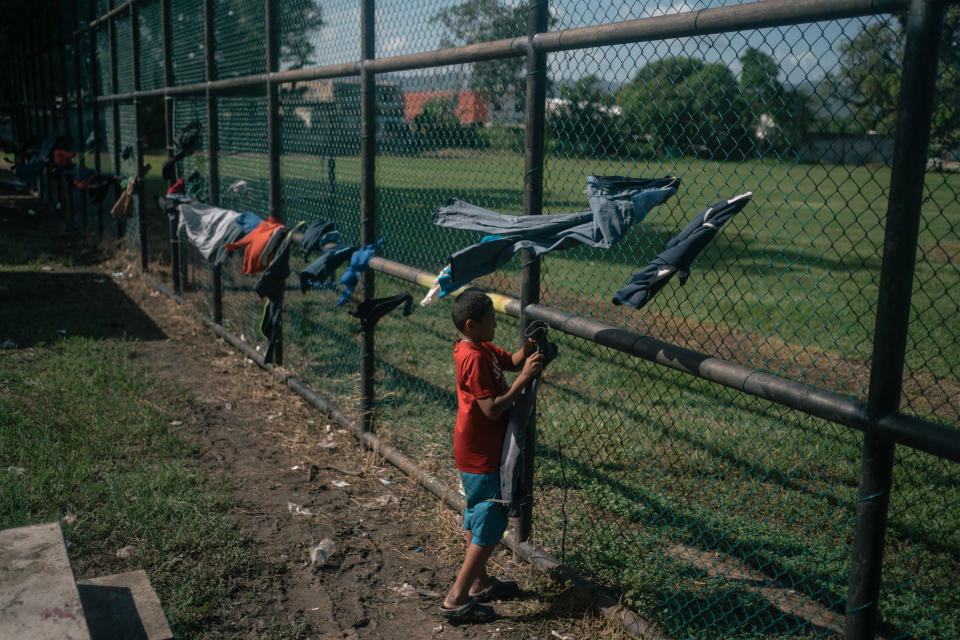 A Central American migrant stand near clothing drying on a fence outside La 72 migrant shelter in the town of Tenosique, Tabasco state, Mexico, on Sunday, Oct. 4, 2020.  / Credit: Bloomberg via Getty