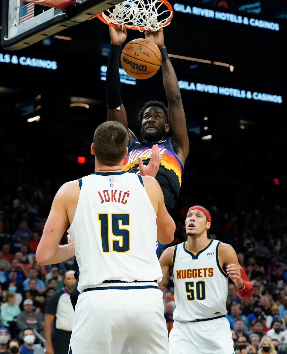 Oct 20, 2021; Phoenix, Arizona, USA; Phoenix Suns center Deandre Ayton (22) dunks the ball over Denver Nuggets center Nikola Jokic (15) at Footprint Center.