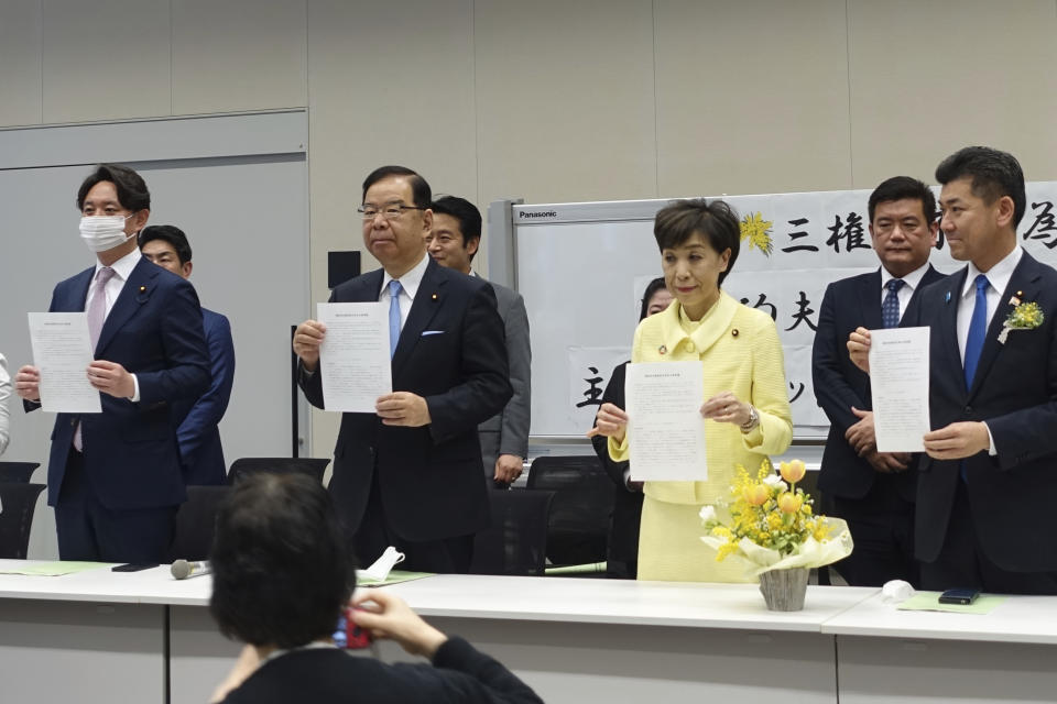 Lawmakers show copies of a joint statement submitted by representatives of women's rights groups on International Women's Day in Tokyo, Wednesday, March 8, 2023. Women's rights activists in Japan renewed their demand Wednesday for the government to allow married couples the option to keep both of their surnames, saying the current practice in which most women face social pressure to adopt their husbands' surnames — a prewar tradition based on paternalistic family values — widens gender inequality. (AP Photo/Mari Yamaguchi)