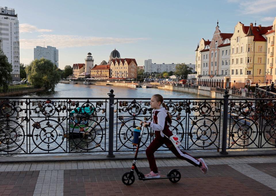 Girl rides scooter over Pregolya River in Kaliningrad