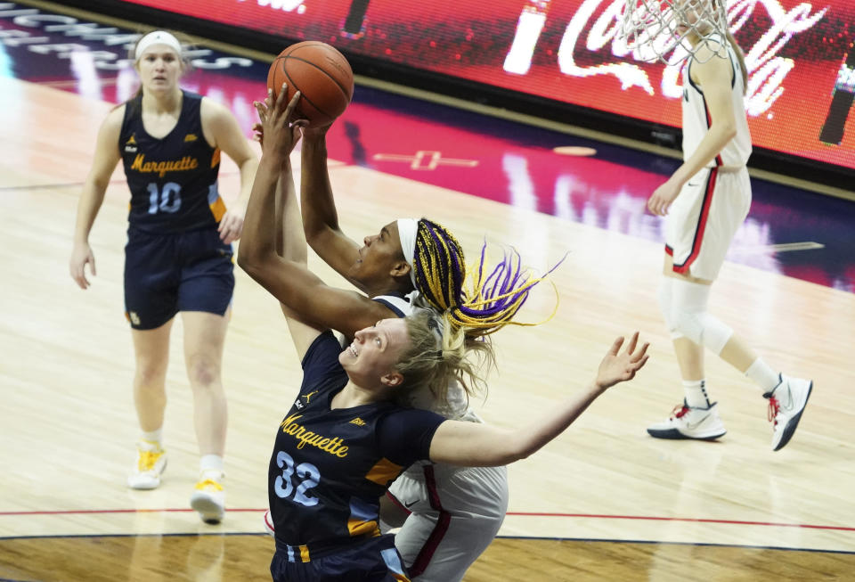 Marquette forward Liza Karlen (32) battles for a rebound against Connecticut forward Aaliyah Edwards, center, in the second quarter of an NCAA college basketball game Monday, March 1, 2021, in Storrs, Conn. (David Butler II/Pool Photo via AP)