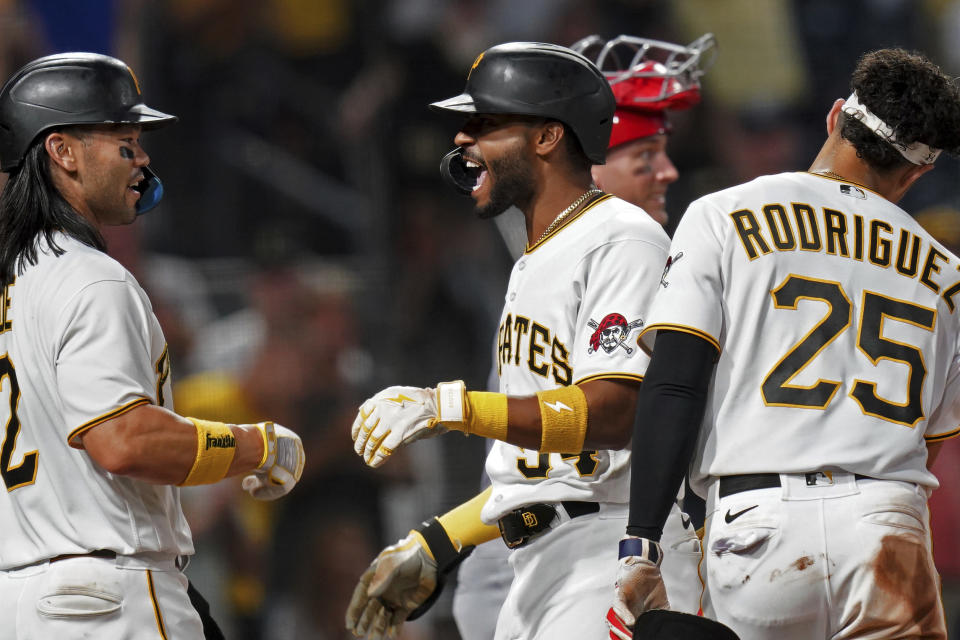 Pittsburgh Pirates' Joshua Palacios, center, celebrates with Connor Joe, left, and Endy Rodriguez, right, after hitting a three-run home run off St. Louis Cardinals starting pitcher Drew Rom in the fourth inning of a baseball game in Pittsburgh, Monday, Aug. 21, 2023. (AP Photo/Matt Freed)