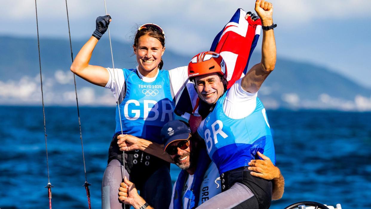Anna Burnet (left) and John Gimson (right) celebrate their silver medal in the mixed Nacra 17 class event in Tokyo 2020