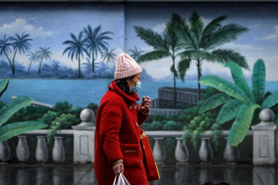 WUHAN, CHINA - FEBRUARY 28 2020: A pedestrian walks by a painted wall in Wuhan in central China's Hubei province Friday, Feb. 28, 2020.