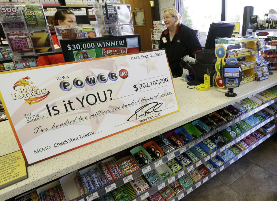 File - in this Sept. 27, 2012 file photo, a Powerball promotional check sits on the counter in the Casey's General Store, in Bondurant, Iowa. The jackpot for Powerball’s Saturday, Nov. 24, 2012, drawing has climbed to $325 million, the fourth-largest in the game’s history. (AP Photo/Charlie Neibergall, File)
