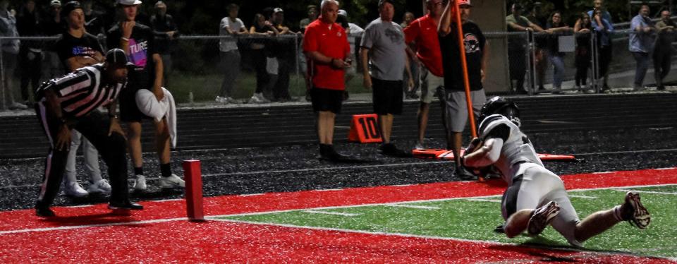 Milan's Connor Dessellier catches a pass and comes down on the goal line for a touchdown to give Milan a 12-6 lead against New Boston Huron on Thursday, Sept. 1, 2022.