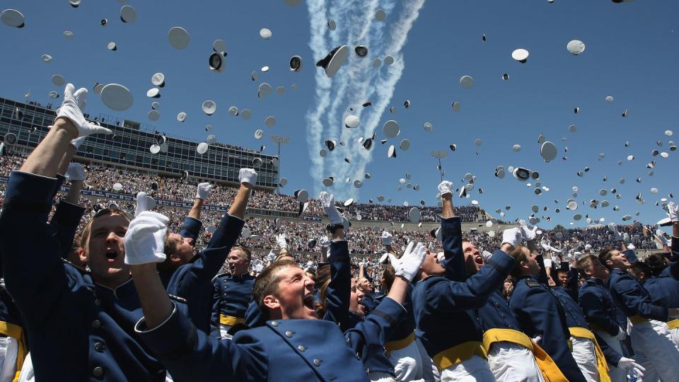 Air Force Academy graduates celebrate as a team of F-16 Thunderbirds flies over during the Air Force Academy graduation ceremony at Falcon Stadium on May 27, 2009 in Colorado Springs, Colorado. Then-Vice President Joe Biden gave the commencement speech. (Photo by John Moore/Getty Images)