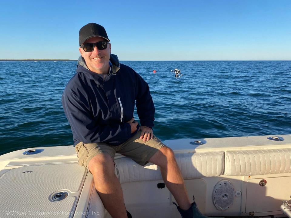 Craig O'Connell waits on a boat near the shark barrier he tested off Cape Cod this fall.