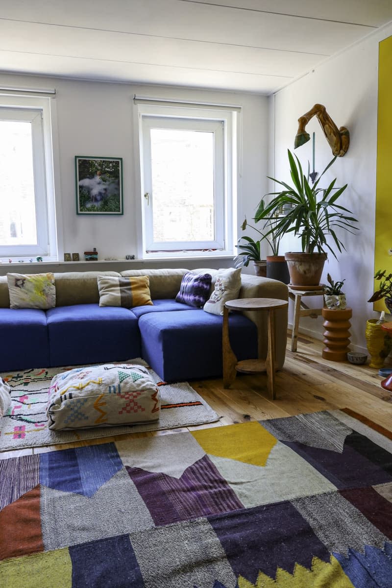 Living room with blue sofa and yellow and other bright colored accents