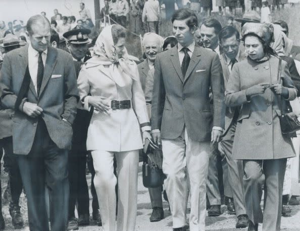 Wearing Pantsuits for protection from the blackflies; Queen Elizabeth (right) and Princess Anne walk