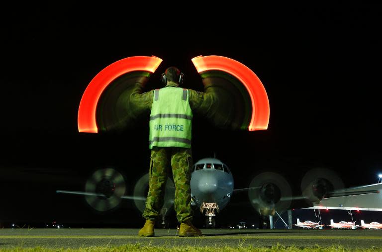 A ground crew directs a Royal Australian Air Force AP-3C Orion upon its return to RAAF base Pearce from searching for the missing Malaysian Airlines flight MH370 over the southern Indian Ocean, in Bullsbrook on March 26, 2014