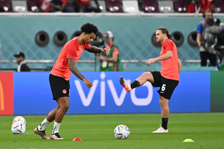 Los jugadores canadienses Tajon Buchanan y Samuel Piette entran en calor antes del partido entre Croacia y Canadá