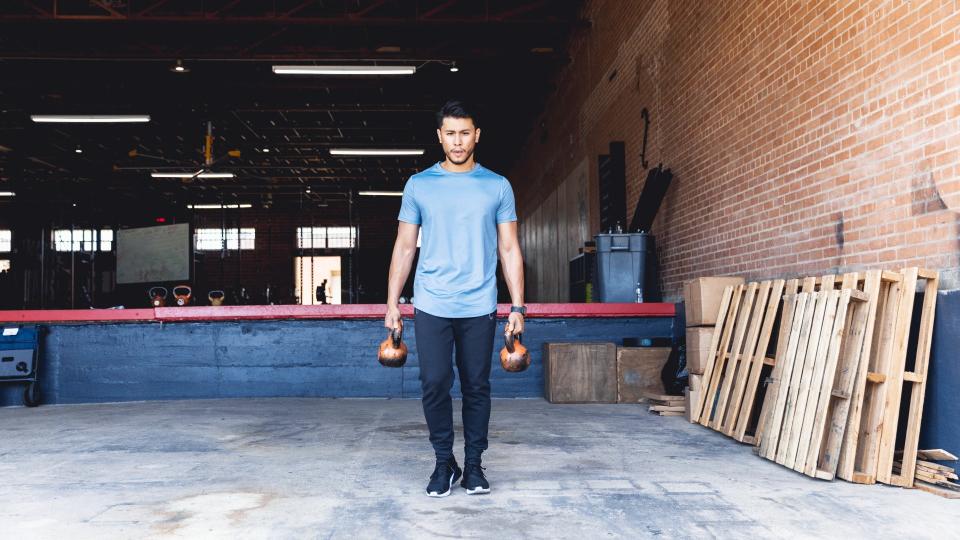 Man performing a farmer's hold with two kettlebells holding one in each hand