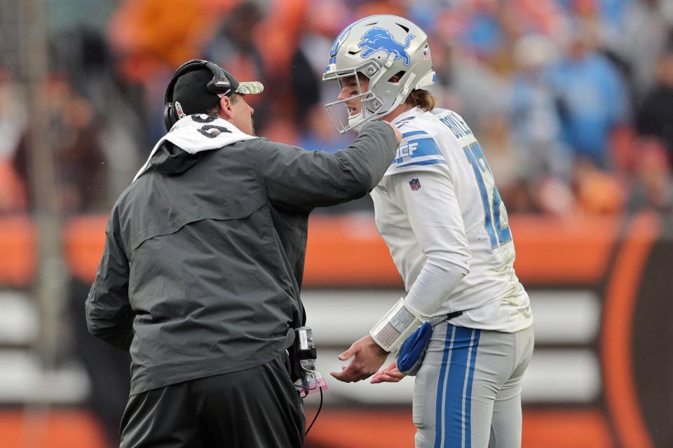 (L-R) Head coach Dan Campbell of the Detroit Lions talks to quarterback Tim Boyle #12 during the second quarter of the game against the Cleveland Browns at FirstEnergy Stadium on November 21, 2021 in Cleveland, Ohio.