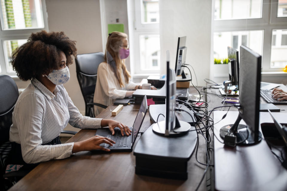 Some employees may continue having to wear masks at work. Image: Getty