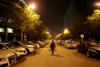 Han Liqun, a HR manager of RenRen Credit Management Co., carries beer and food for his colleagues as he walks to the office after midnight, in Beijing, China, April 27, 2016. REUTERS/Jason Lee