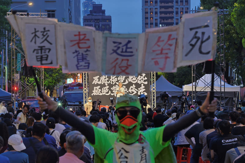 「反對核電延役」晚會  濟南路舉行（1） 立法院教育文化委員會預計10日由國民黨召委柯志恩 排審「核子反應器設施管制法」修法。全國廢核行動 平台「反對核電延役，拒絕草率修法」晚會9日在濟 南路上舉行，一名參加者身穿綠色鳥裝，高舉標語表 達訴求。 中央社記者王飛華攝  113年7月9日 