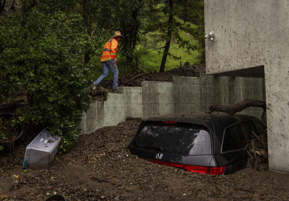 A geologist surveys a mudslide Tuesday, Feb. 6, 2024, in the Beverly Crest area of Los Angeles. (AP Photo/Ethan Swope)