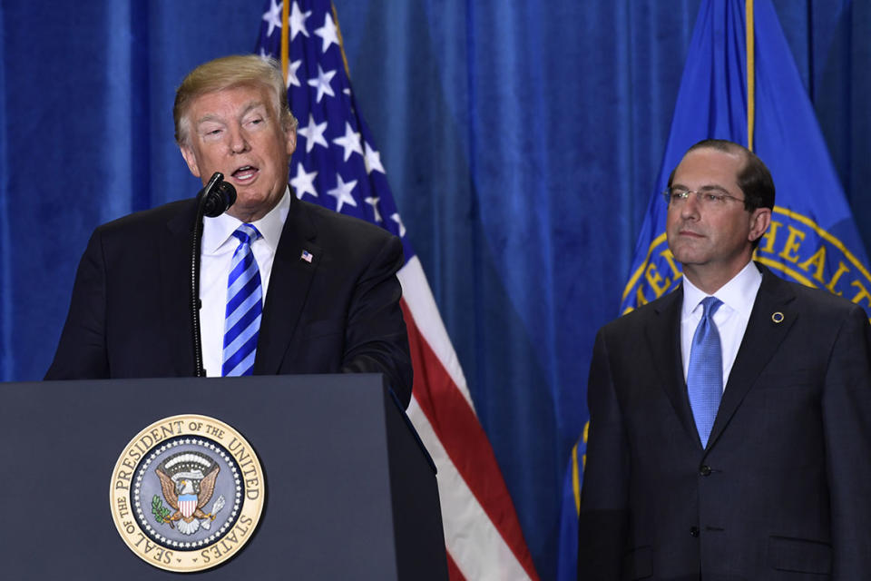 President Donald Trump, left, standing with Health and Human Services Secretary Alex Azar, right, talks about drug prices during a visit to the Department of Health and Human Services in Washington, Thursday, Oct. 25, 2018. (AP Photo/Susan Walsh)