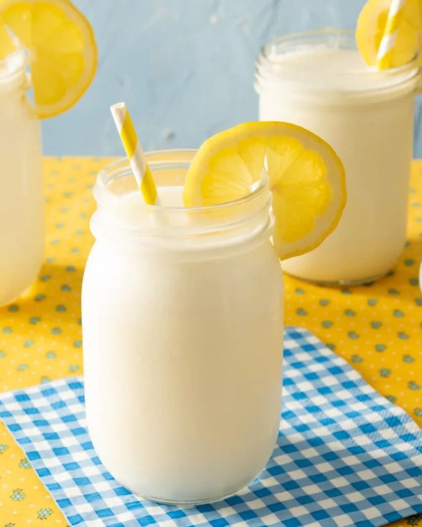 frozen lemonade in mason jar with yellow straw and lemon wedge
