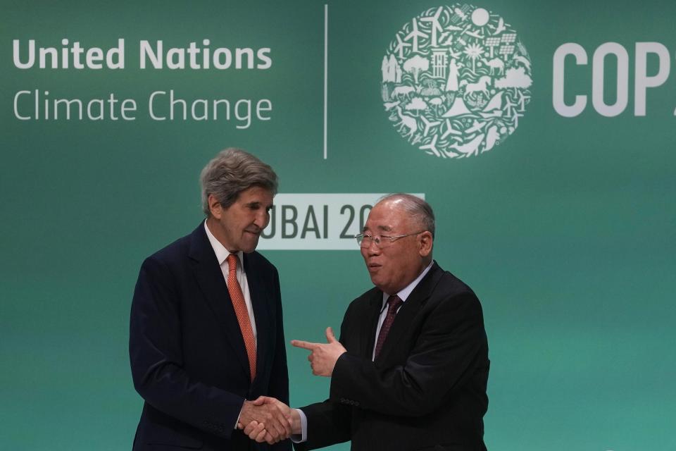 ARCHIVO - John Kerry, enviado especial presidencial de Estados Unidos para el clima, izquierda, y Xie Zhenhua, enviado especial de China para el clima, se estrechan la mano antes de una conferencia de prensa en la cumbre climática COP28, el 13 de diciembre de 2023, en Dubái, Emiratos Árabes Unidos. (AP Foto/Rafiq Maqbool, archivo)