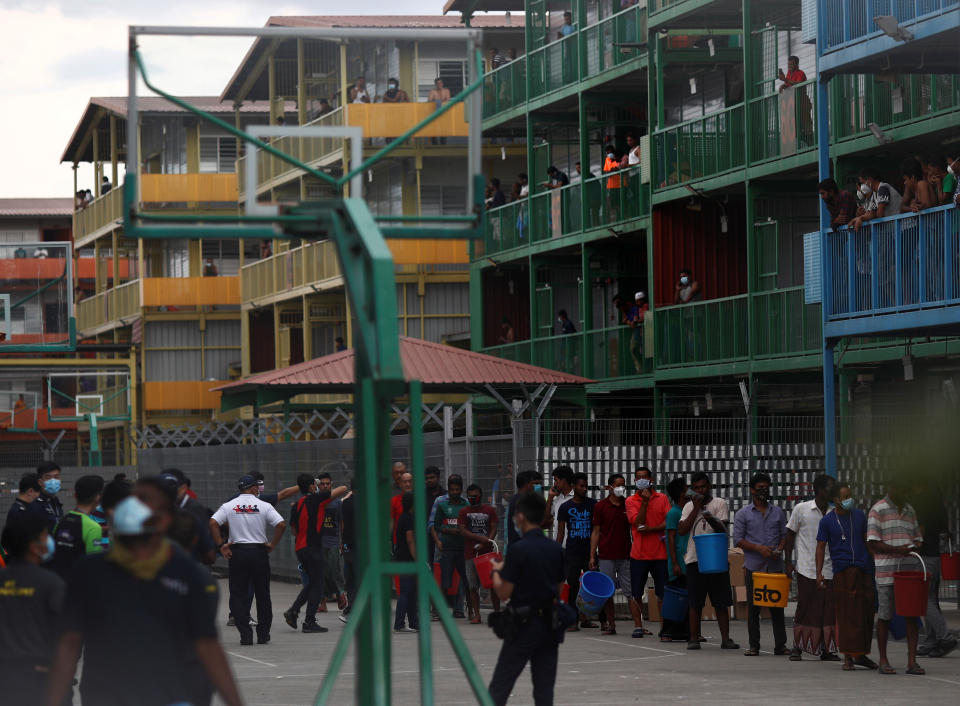 Migrant workers queue to collect food at the Punggol S11 dormitory during the coronavirus outbreak (COVID-19) in Singapore April 6, 2020. Picture taken April 6, 2020. REUTERS/Edgar Su