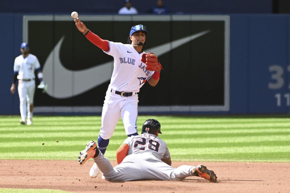 Toronto Blue second baseman Santiago Espinal, top, throws to first base to put out Detroit Tigers' Miguel Cabrera after forcing out Javier Baez at second base in the fourth inning of a baseball game in Toronto, Saturday, July 30, 2022. (Jon Blacker/The Canadian Press via AP)