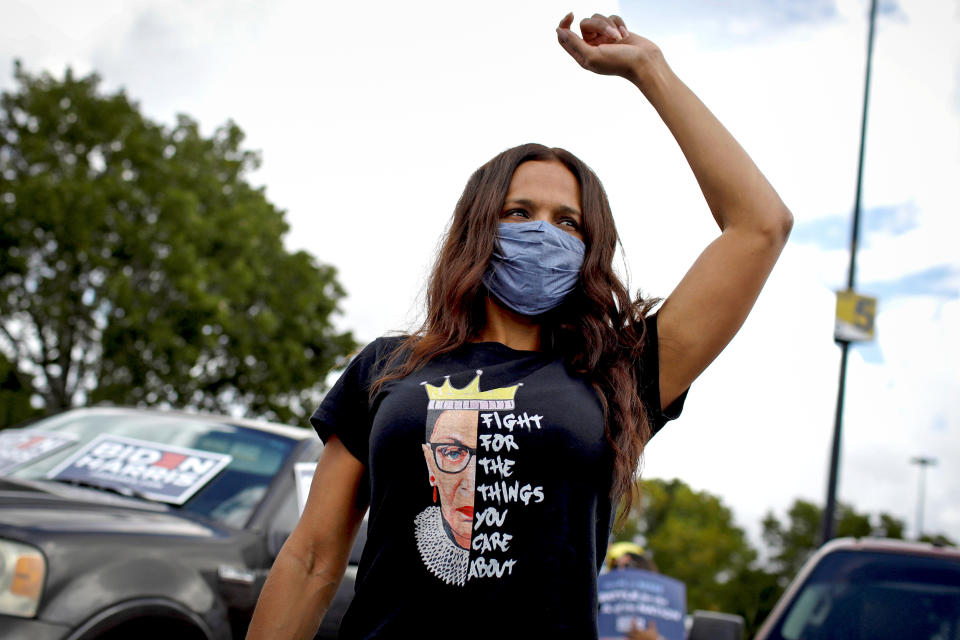 A woman wearing a t-shirt depicting the late Supreme Court Justice Ruth Bader Ginsburg listens to U.S. Democratic vice presidential nominee Senator Kamala Harris in Miami (Marco Bello / Reuters file)